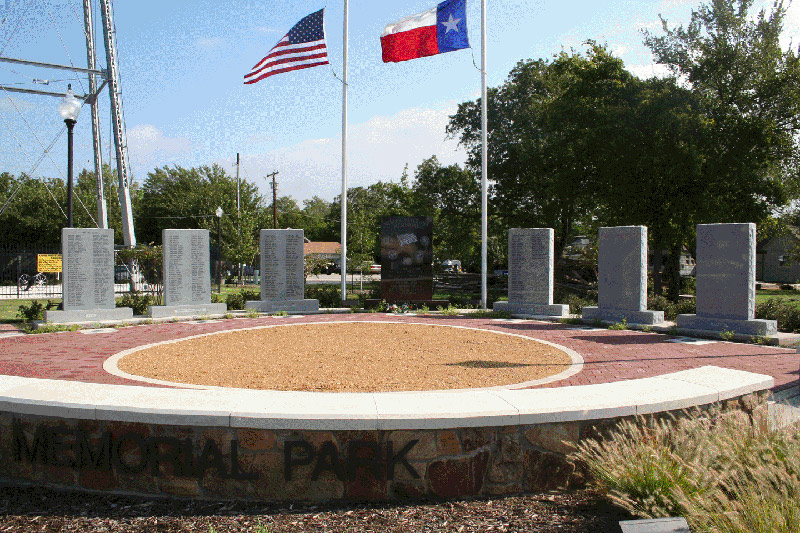 Civic veterans memorial park with granite panels and flags flying