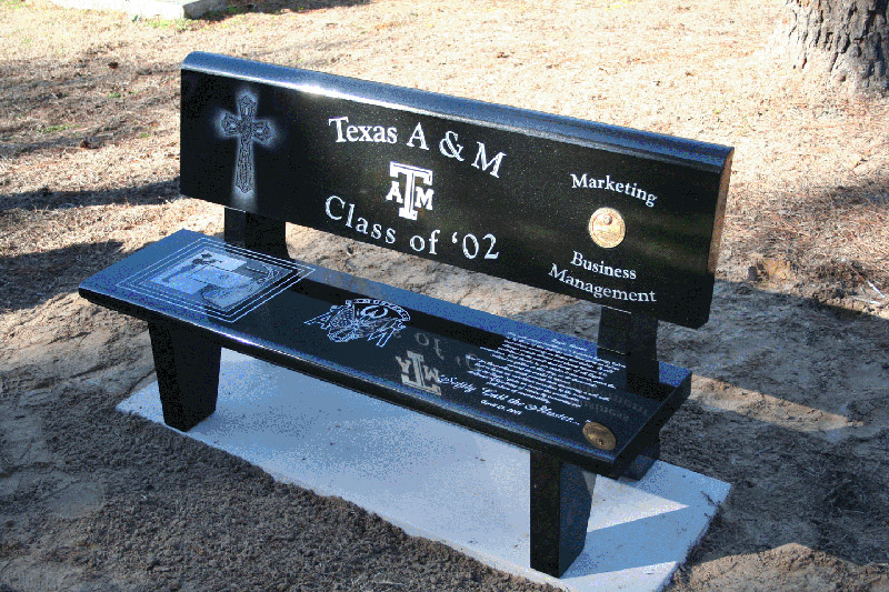 Black granite memorial bench with etched lettering and emblems