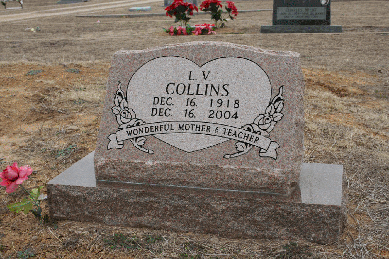 Rose granite upright monument with a carved heart panel and ribbon banner