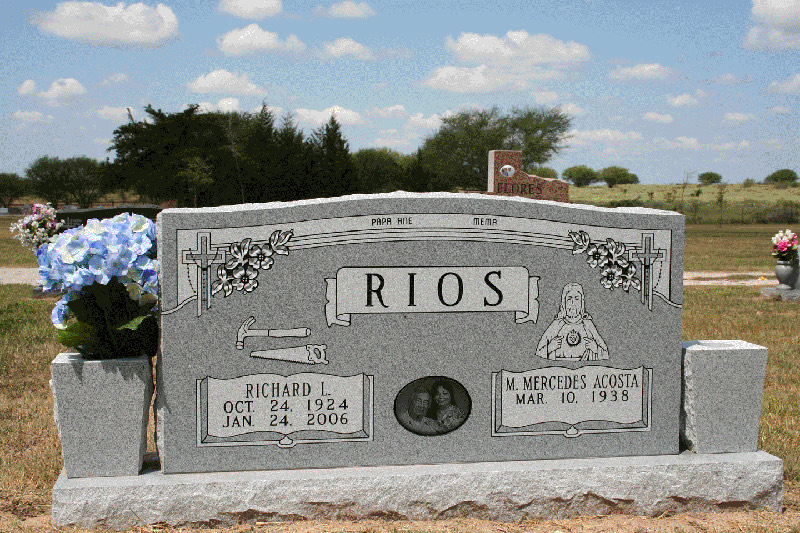 Grey upright monument with carved crosses, flowers and an oval porcelain portrait
