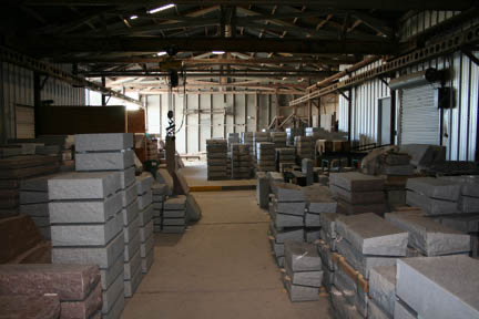 Inside the Riley-Gardner warehouse, granite bases and monuments stacked in rows