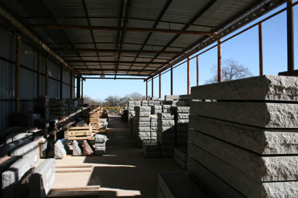 Granite bases and slabs stacked under the covered yard at the Riley-Gardner works